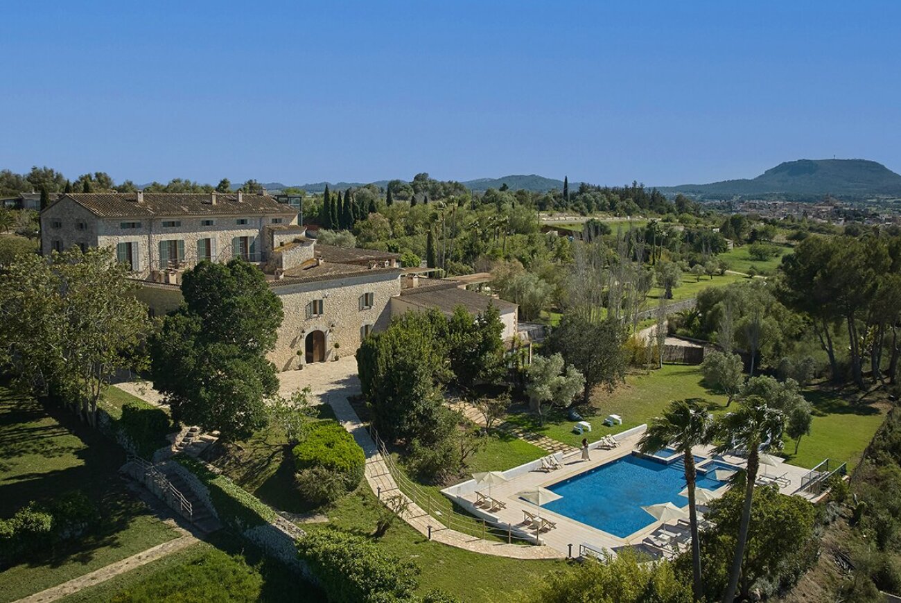 Aerial view of the stone estate buildings, gardens and outdoor pool