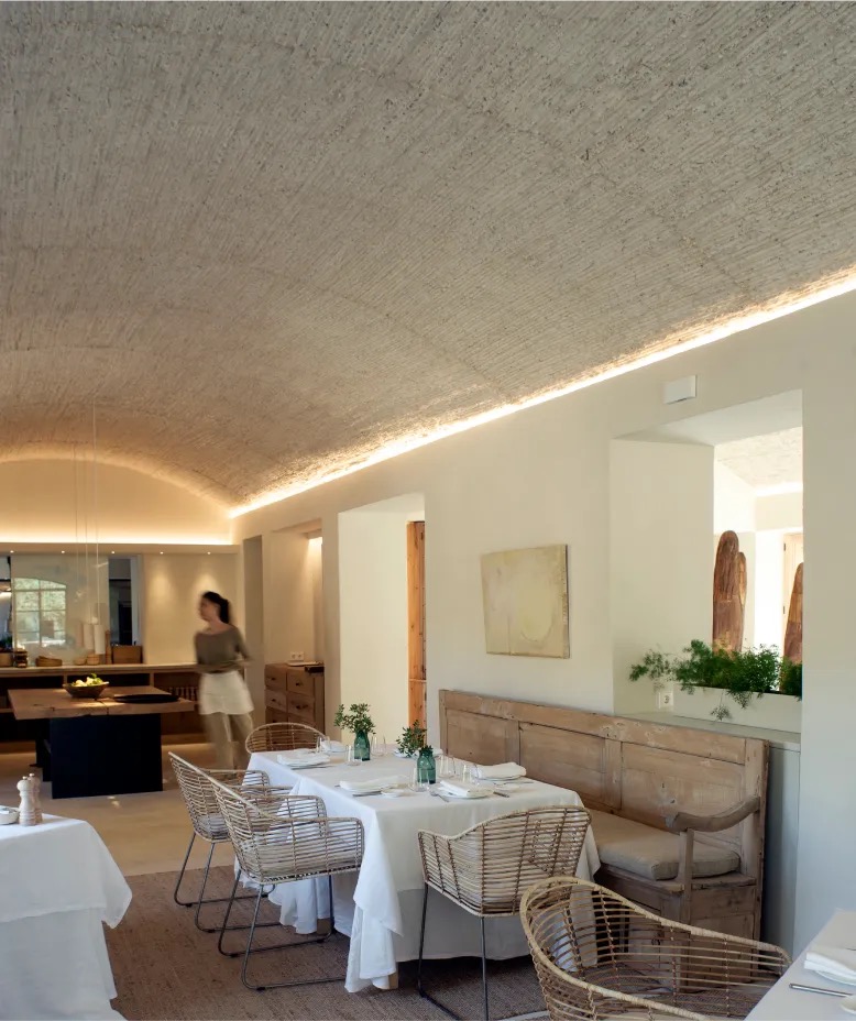 Restaurant dining room with a vaulted ceiling and set tables