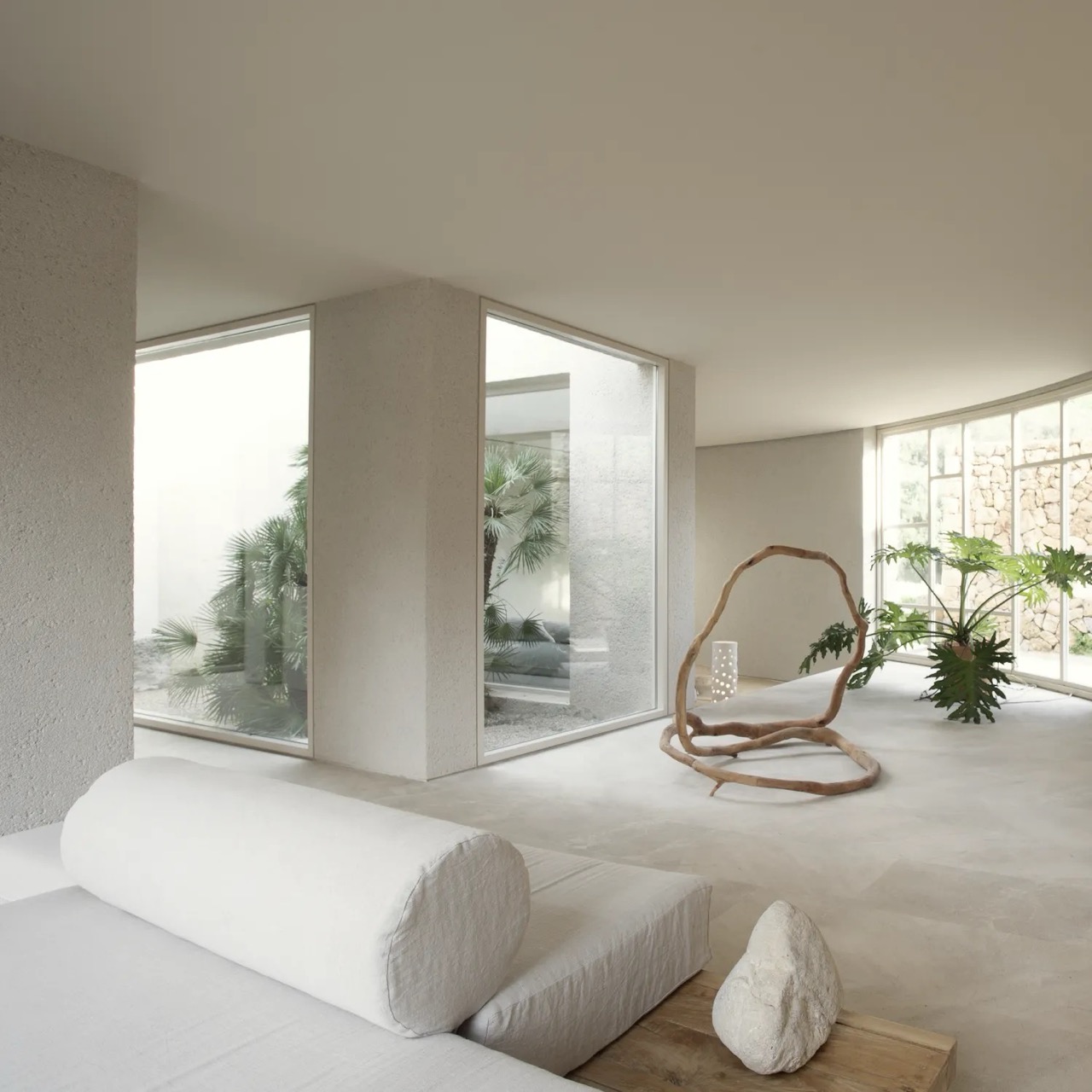 Minimalist spa relaxation room with large windows and palm views