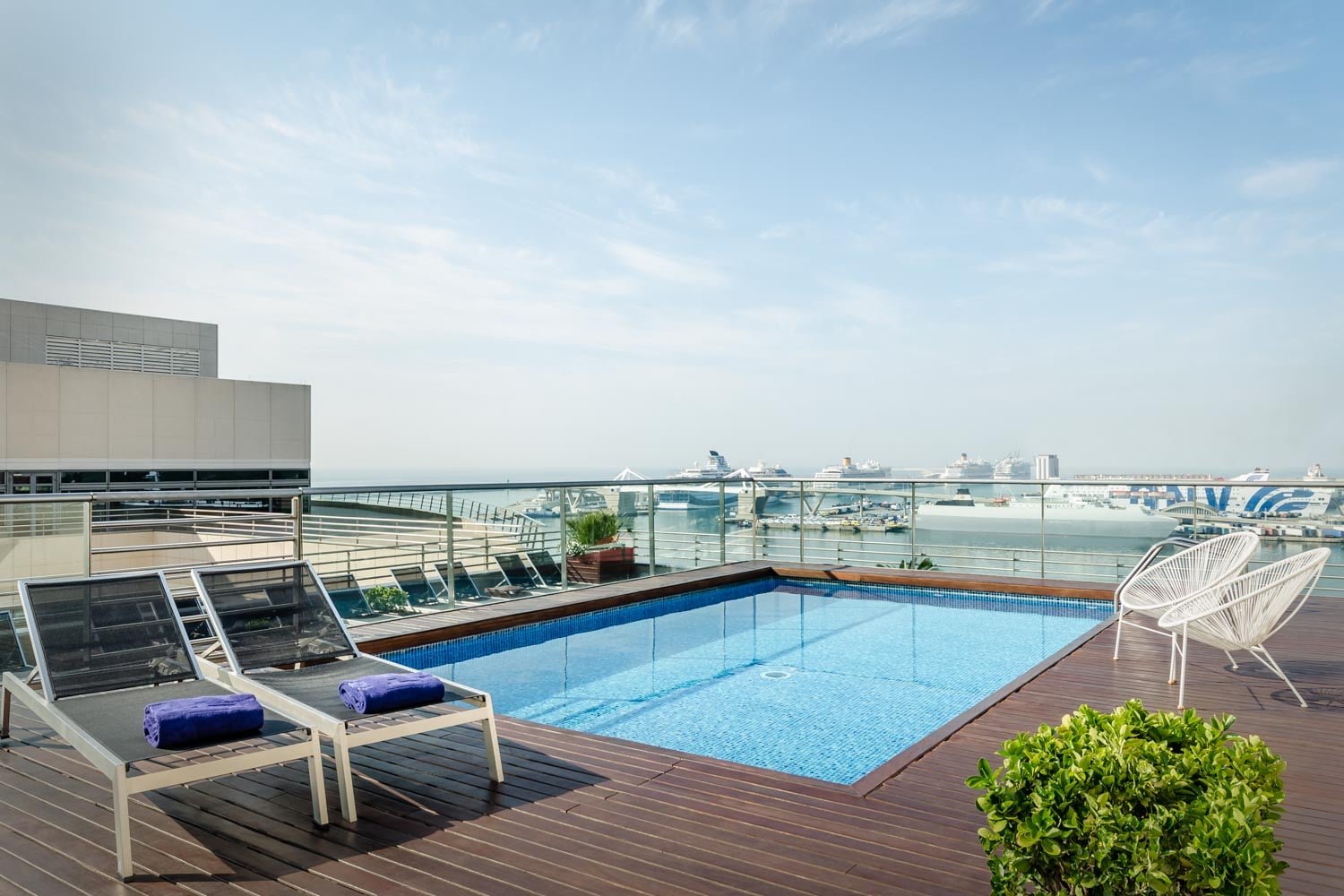 Rooftop pool with loungers overlooking the Port of Barcelona