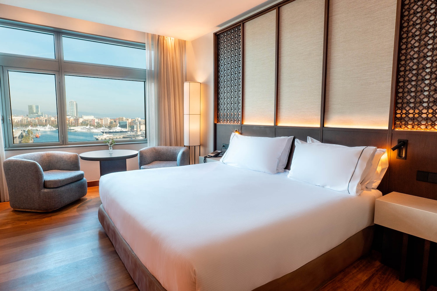 Guest room with a king bed and a floor-to-ceiling window over the marina