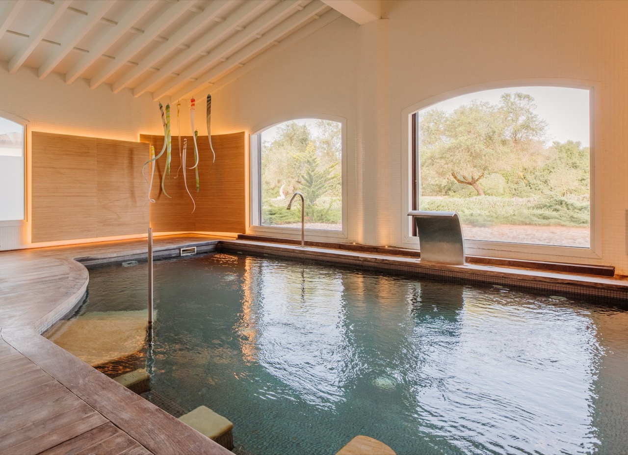 Indoor thermal spa pool at Fontsanta Hotel with arched windows looking onto the grounds
