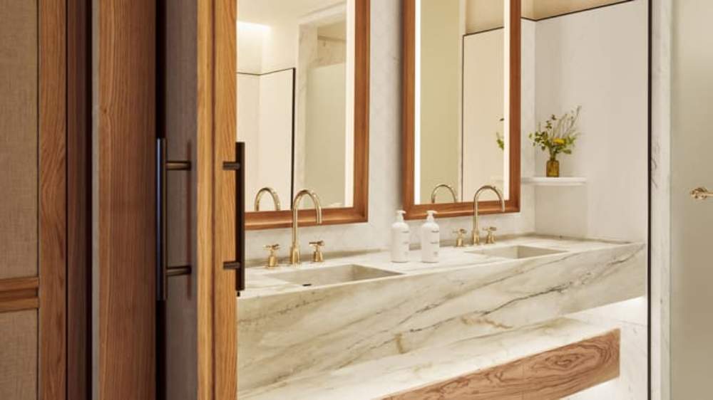 Marble double vanity bathroom with wood framed mirrors