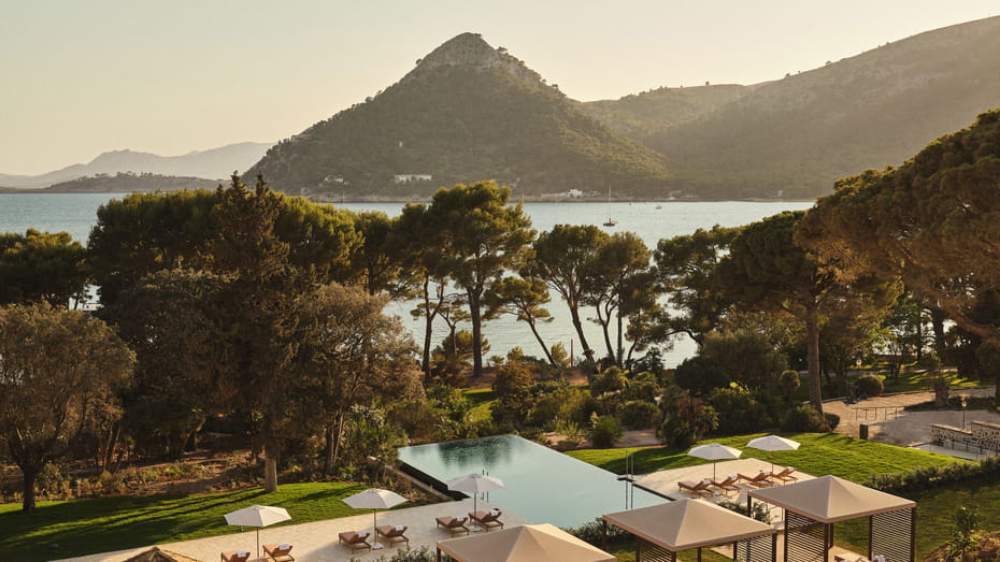 Infinity pool and gardens overlooking the bay with mountains behind at Four Seasons Resort Mallorca at Formentor