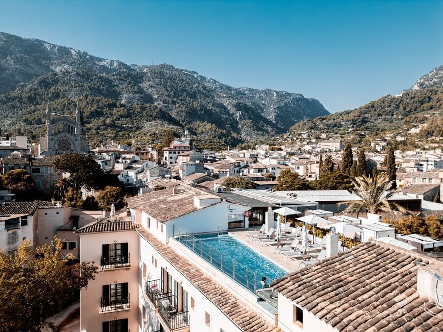 Aerial view of the rooftop pool and terrace over Soller's rooftops with mountains behind