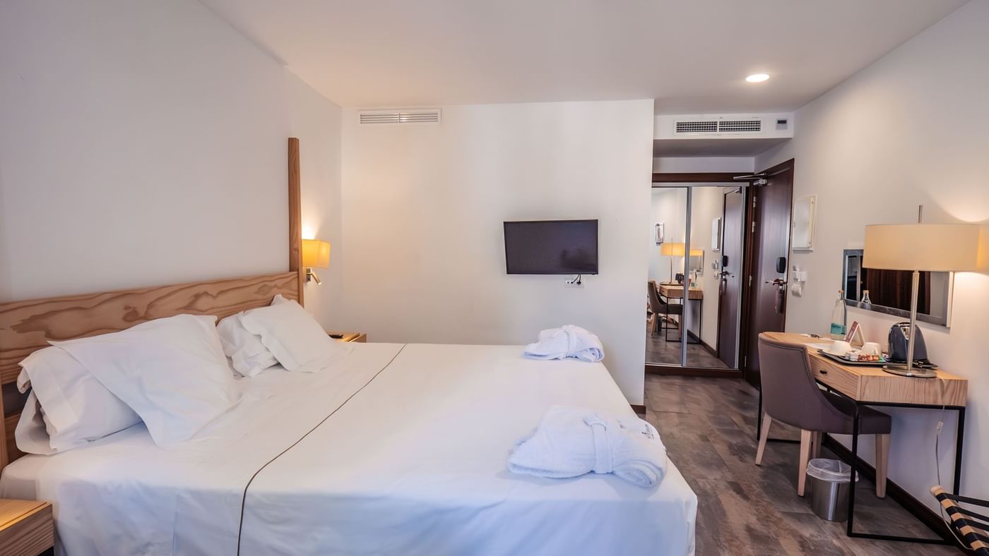 Standard double room with a wood headboard and desk area