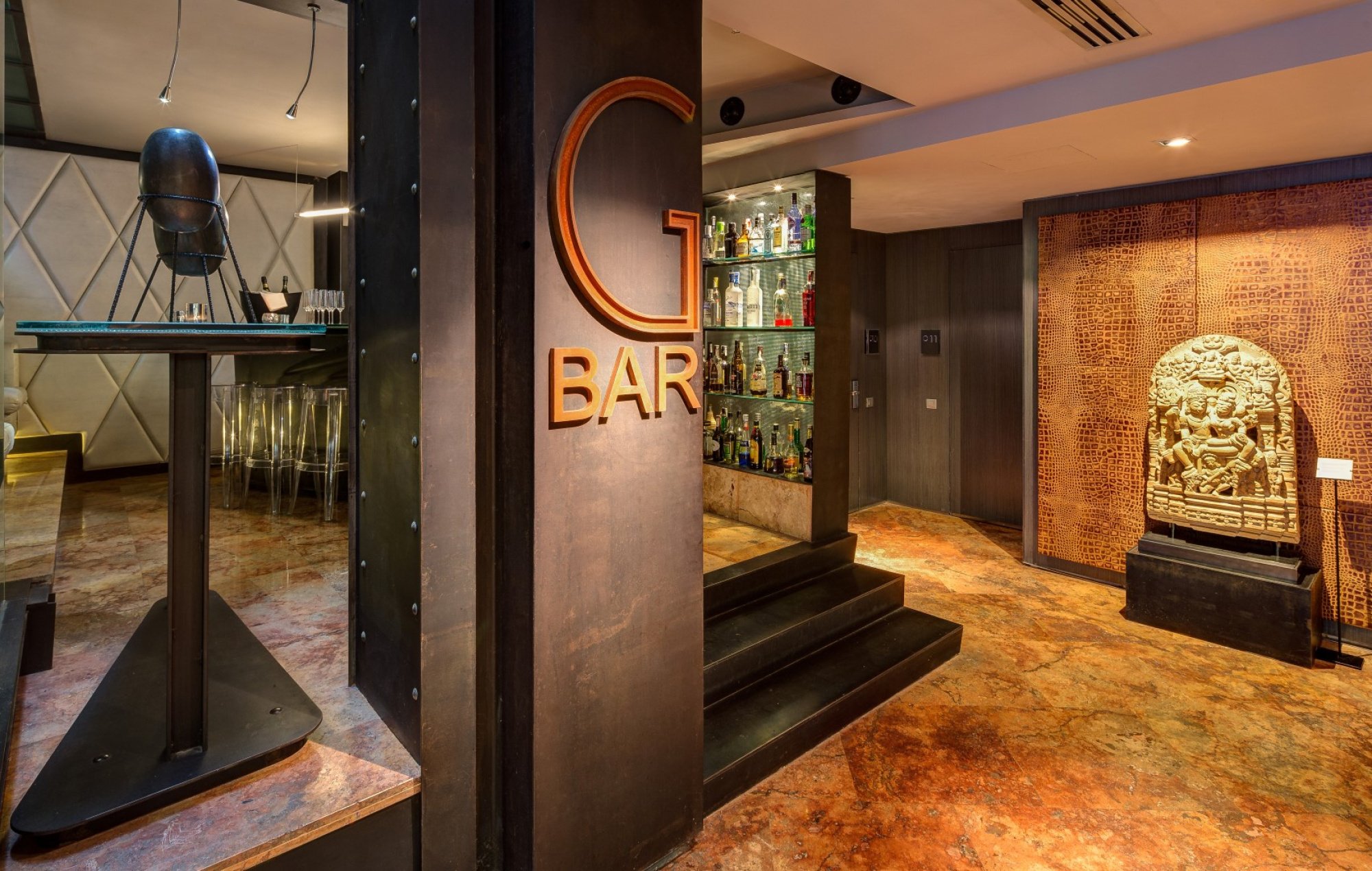 G Bar at Hotel Granados 83, with its large 'G BAR' sign, a carved stone relief on the wall and a dark marble floor