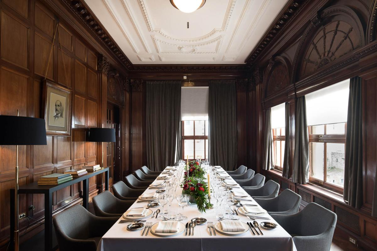 Wood-paneled private dining room with a long table set for a group