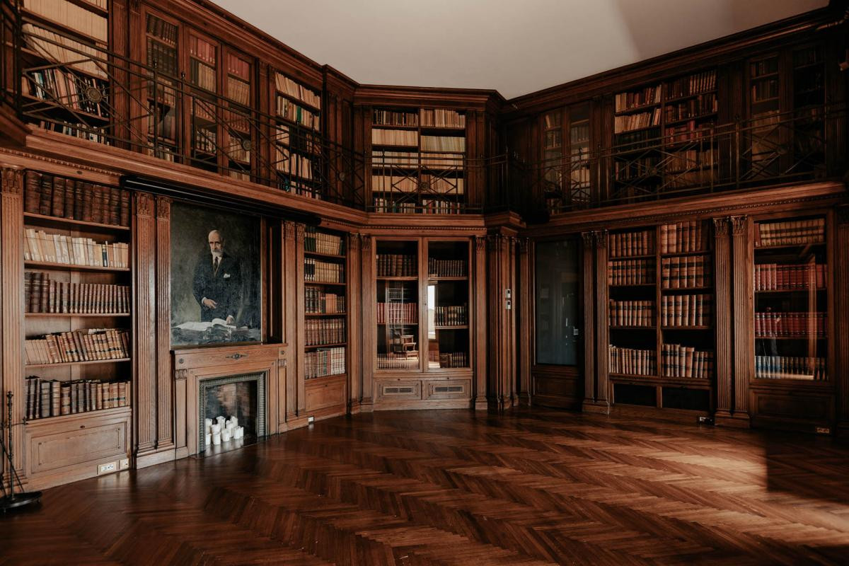 Historic wood-paneled library with a fireplace and a portrait
