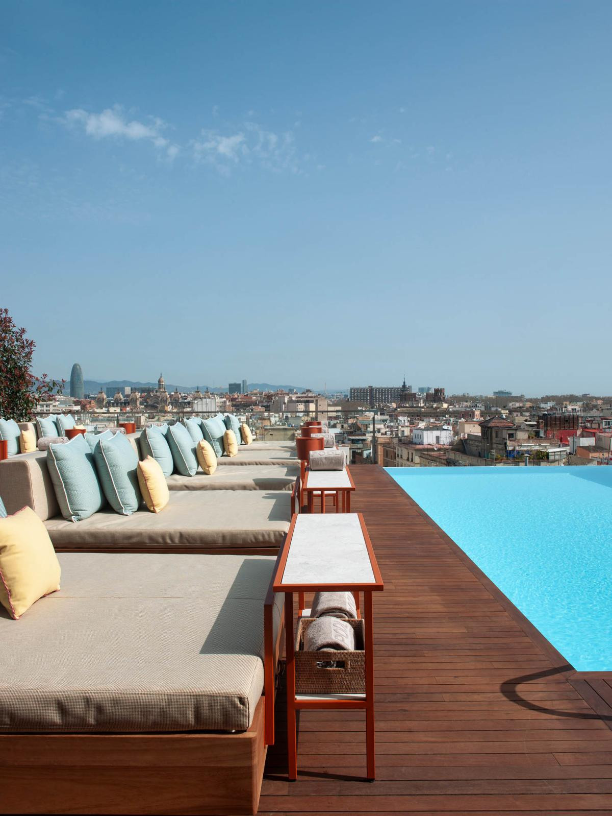 Rooftop infinity pool and lounge deck with a Barcelona skyline view