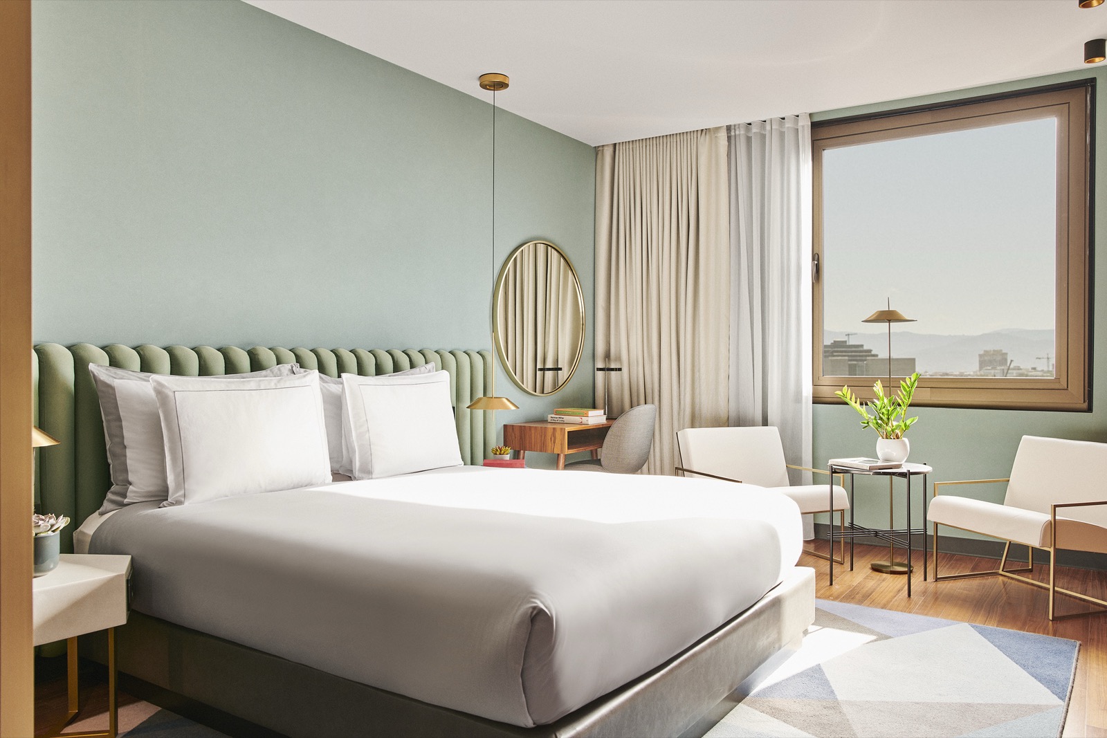 Bedroom with a sage-green channel-tufted headboard