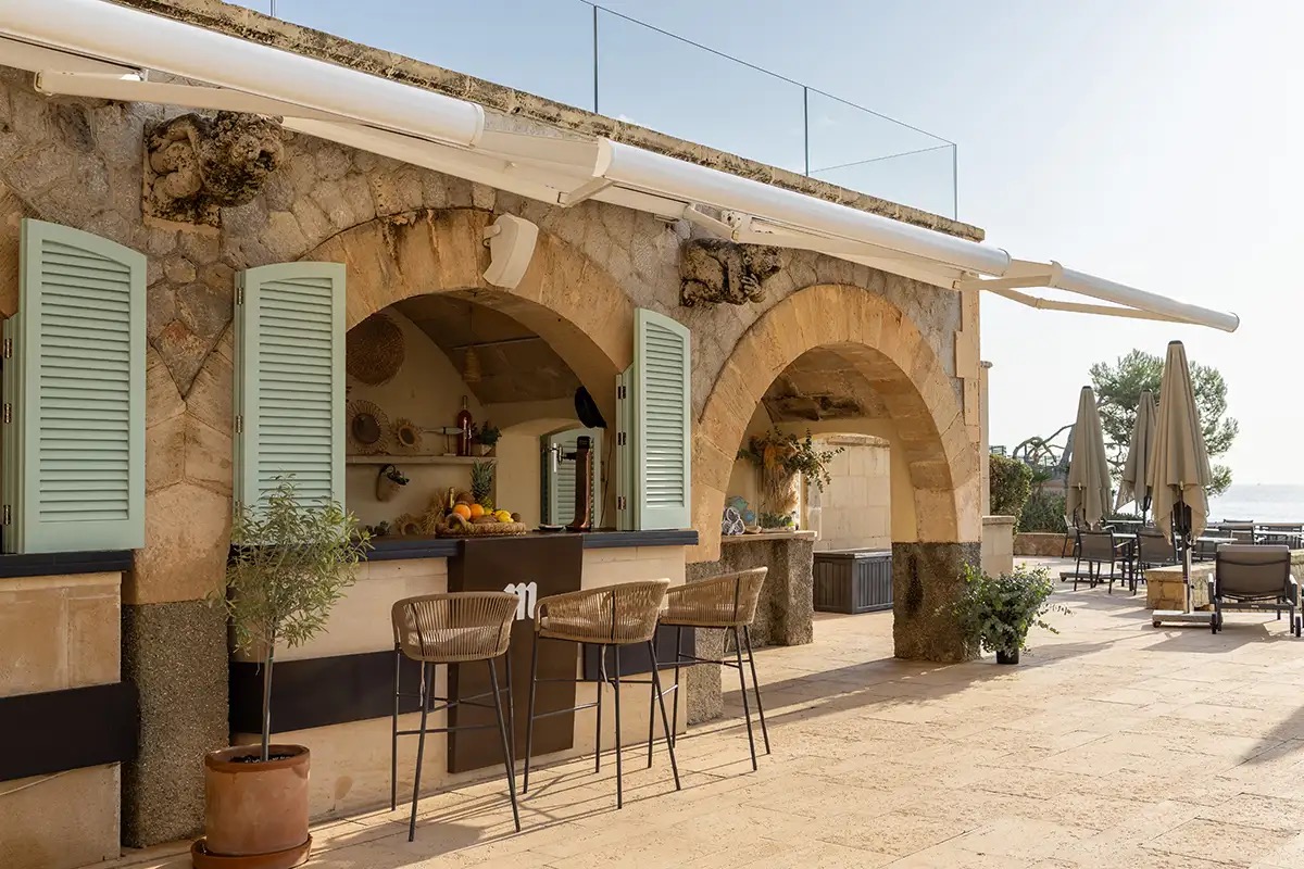 Stone archway outdoor bar with stools facing the sea