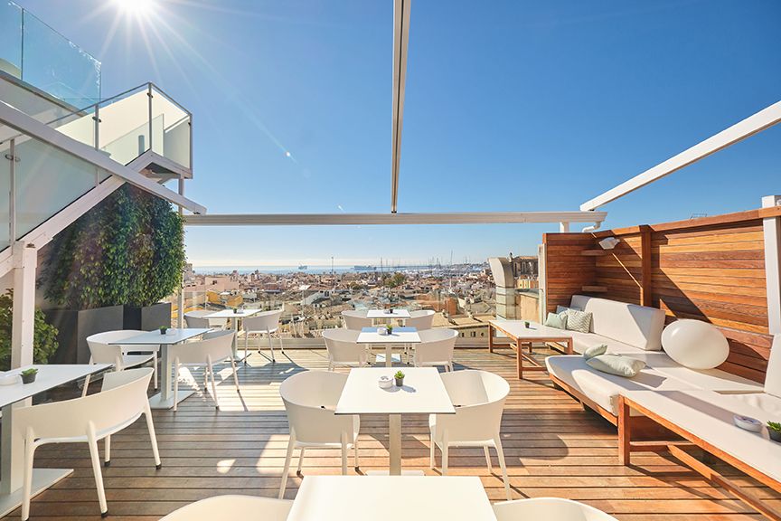 SkyArea rooftop terrace with white lounge seating and a panoramic view over Palma's rooftops to the sea