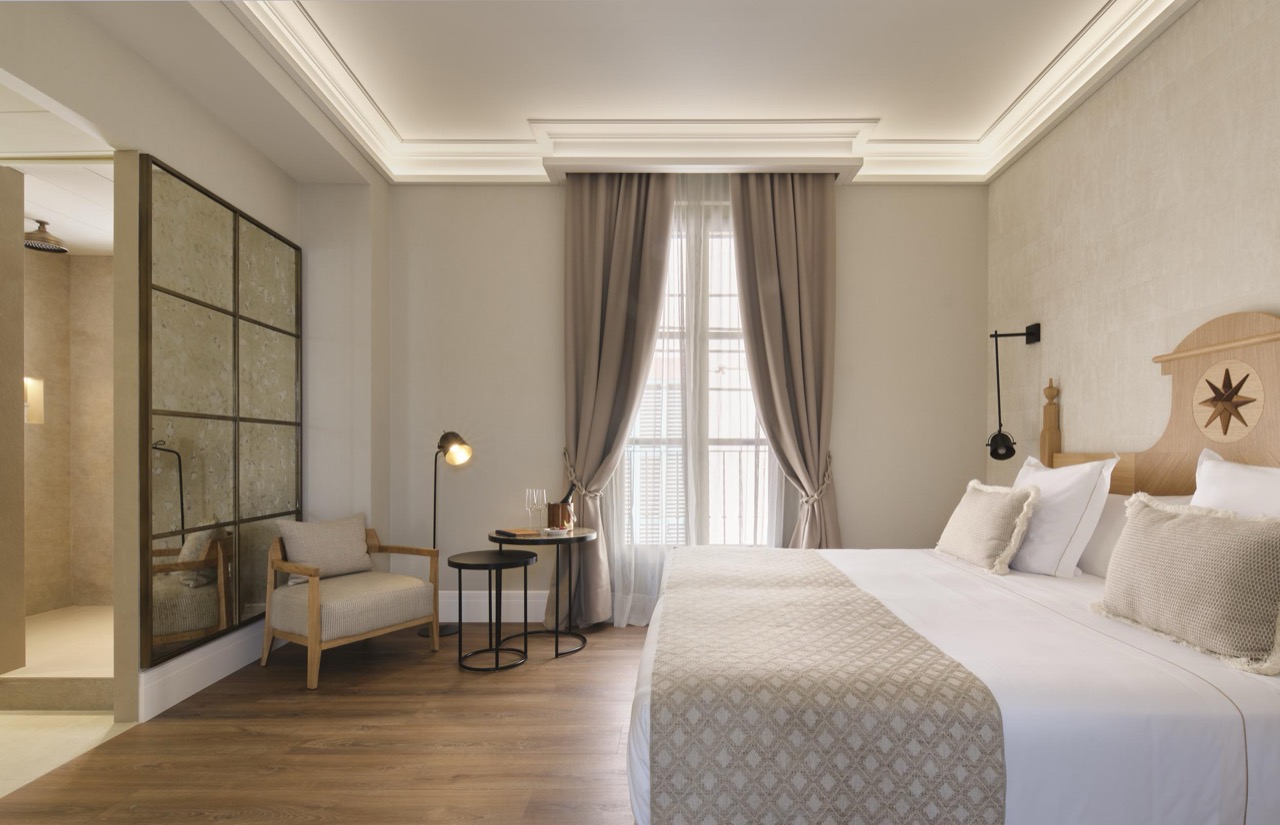 Superior room with a curtained window, armchair and ensuite shower