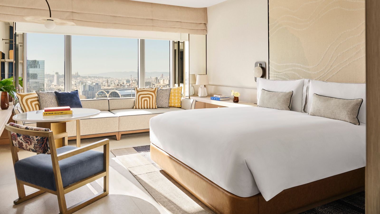 Guest room with a king bed, daybed and a floor-to-ceiling city-view window