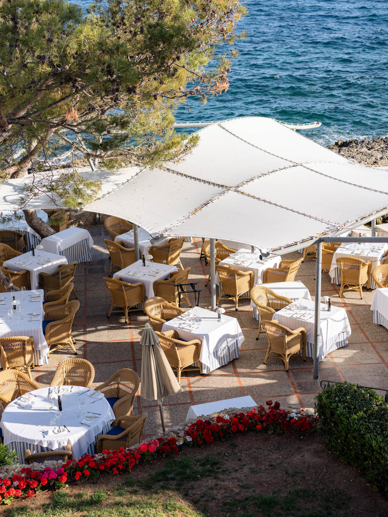 Las Terrazas de Bendinat restaurant terrace with wicker chairs and set tables overlooking the sea