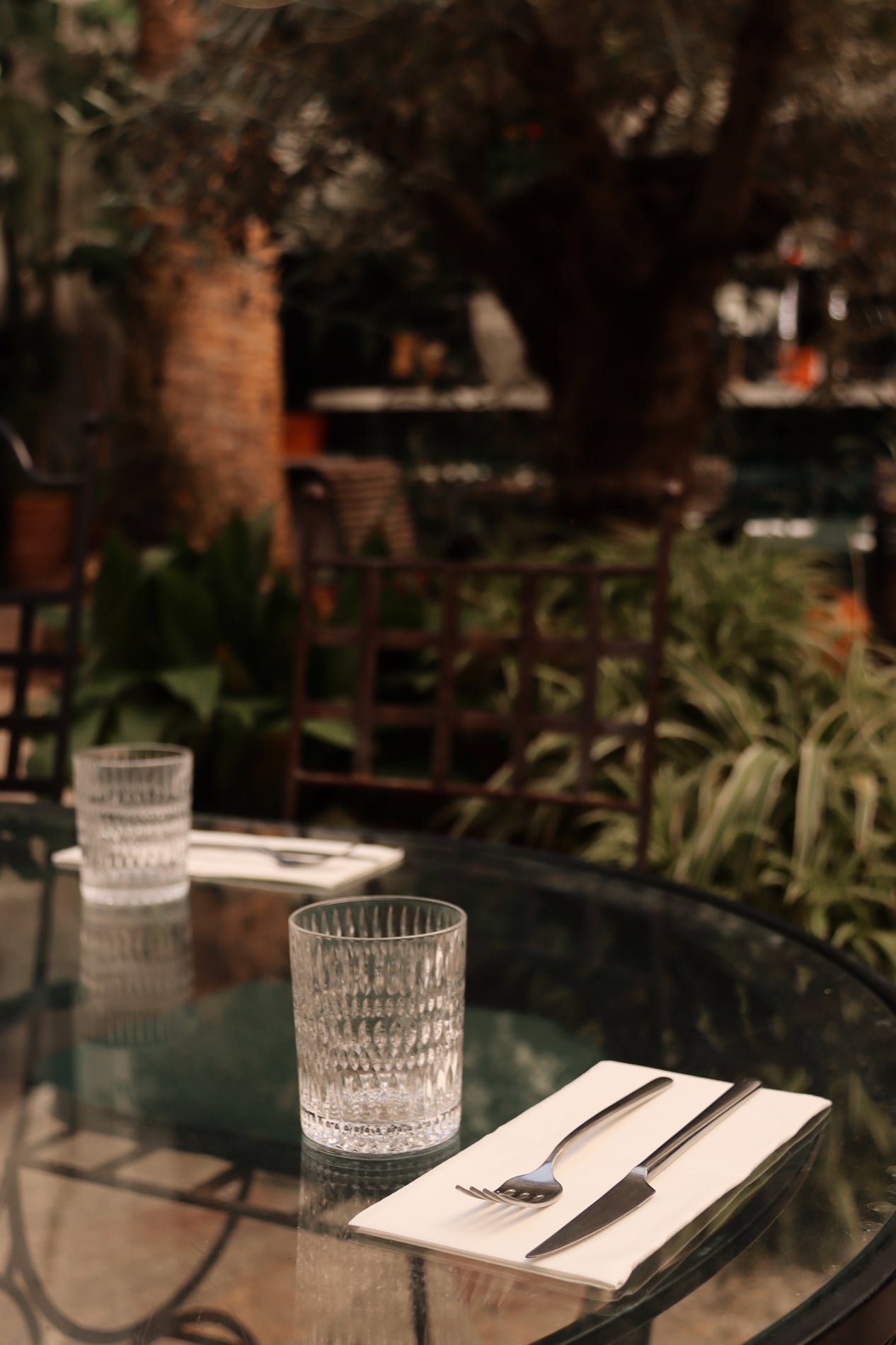 Outdoor dining table set with glassware and cutlery on the courtyard terrace