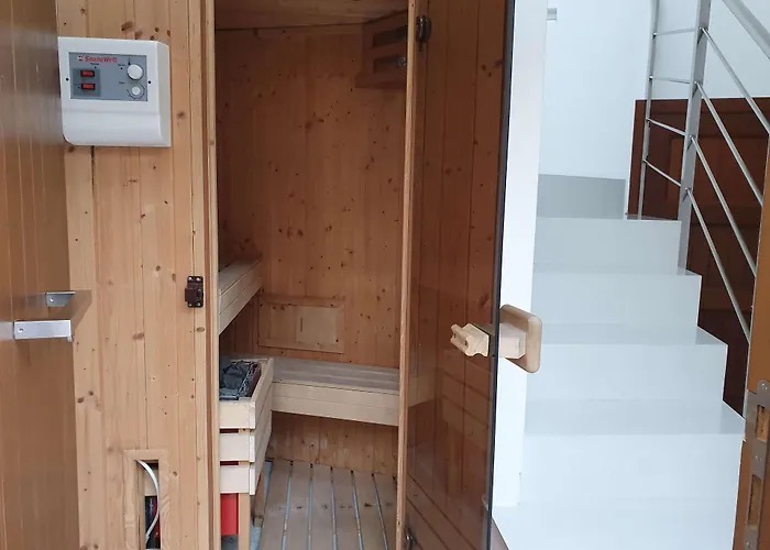 In-room wooden sauna with benches and digital control panel