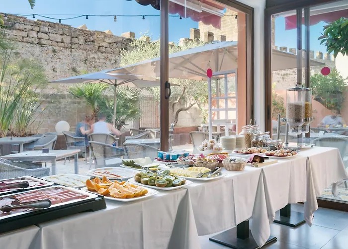 Breakfast buffet spread on the courtyard terrace, backed by the old town's stone ramparts