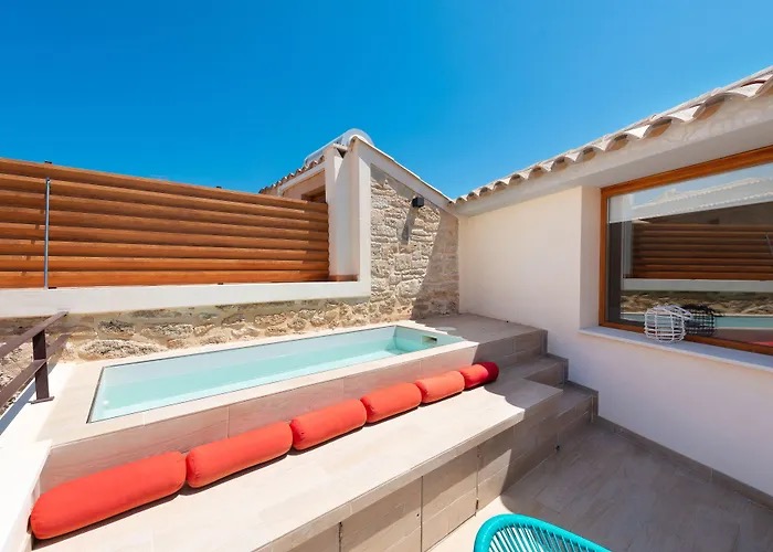 Private rooftop plunge pool with a wood-slat privacy screen and orange cushioned bench seating