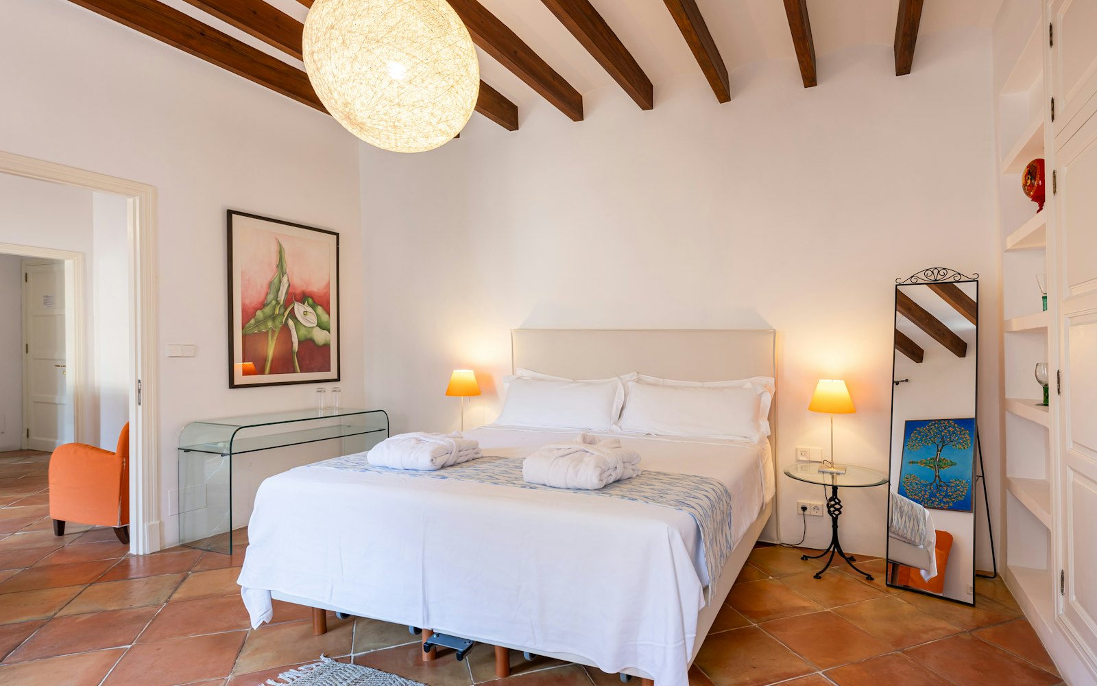 Junior suite bedroom with exposed wood ceiling beams and a large woven pendant lamp