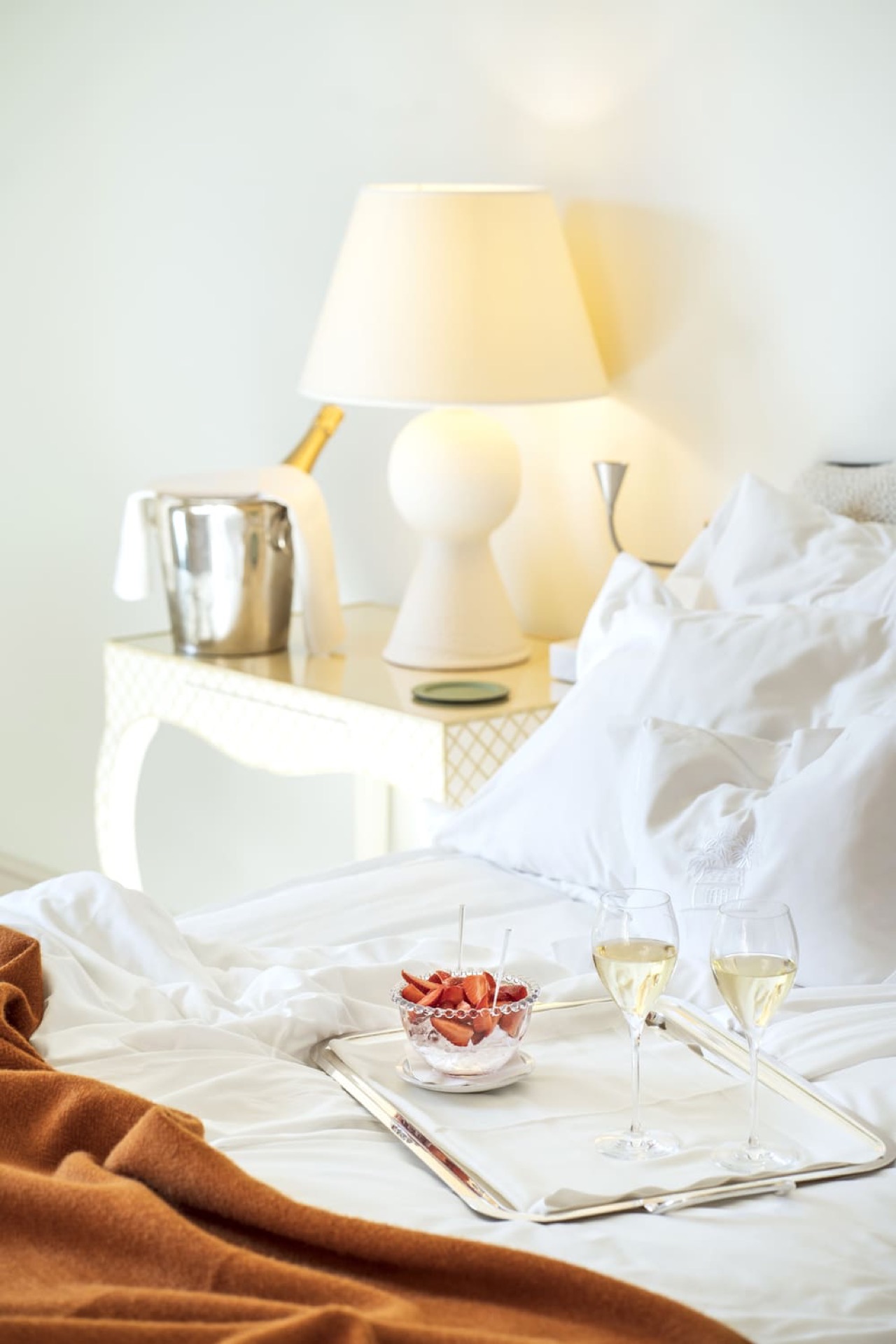 Hotel room bed with a champagne and strawberries tray