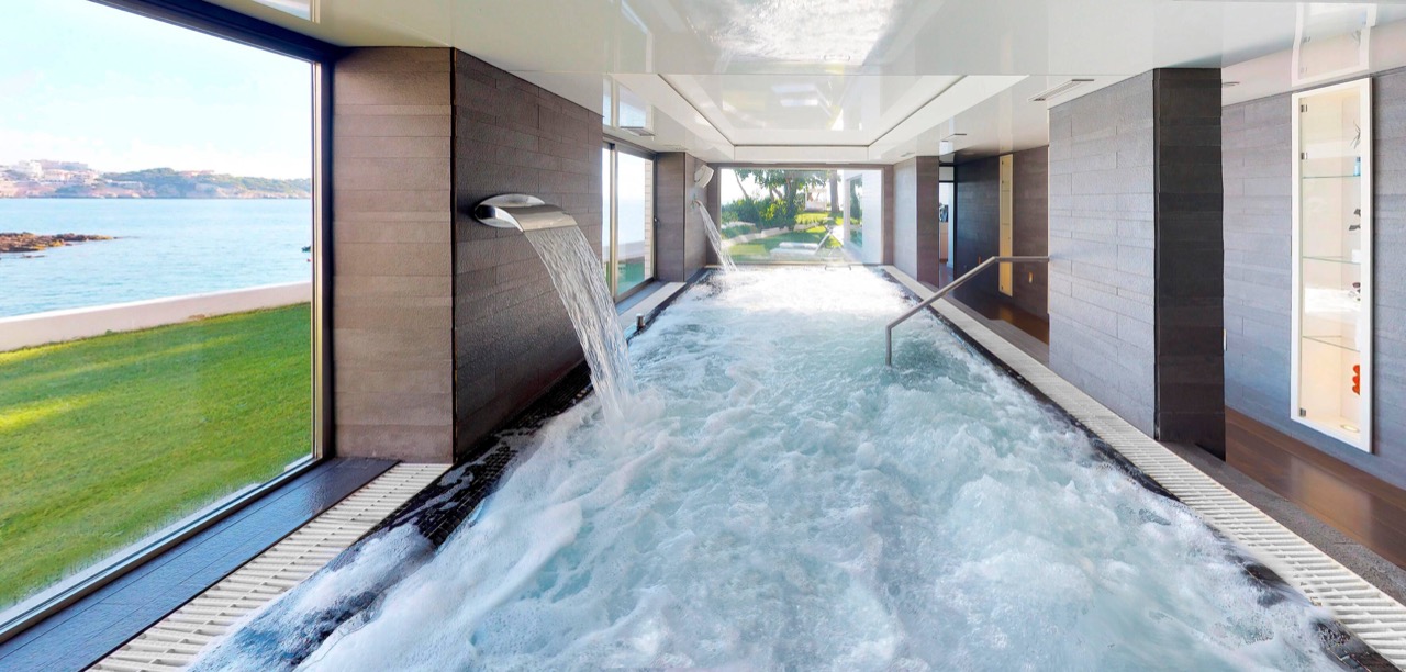 Indoor spa water circuit with a waterfall feature and sea view