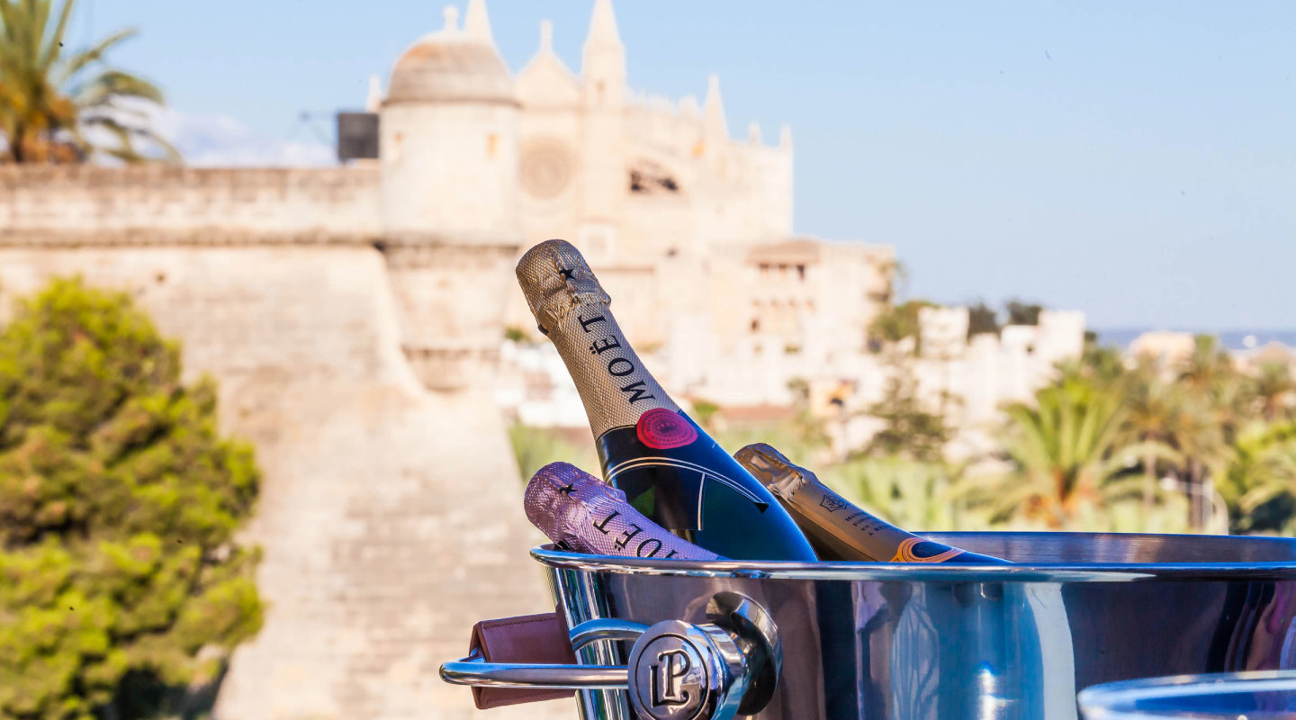 Champagne bottles chilling in an ice bucket on the rooftop Sky Bar, with Palma Cathedral in the background