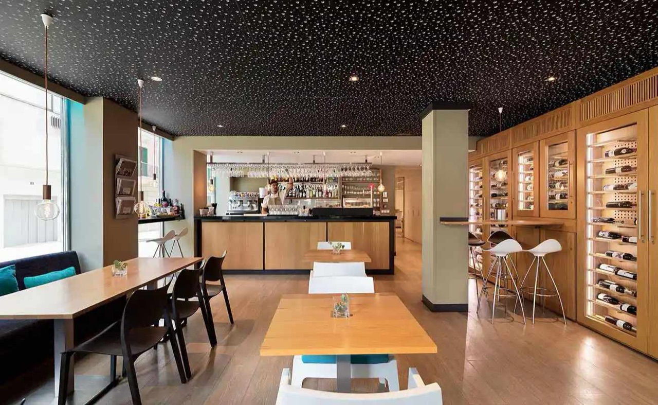 Gastrobar Saratoga's dining room, with a wine display wall, a starlit ceiling and wooden tables.