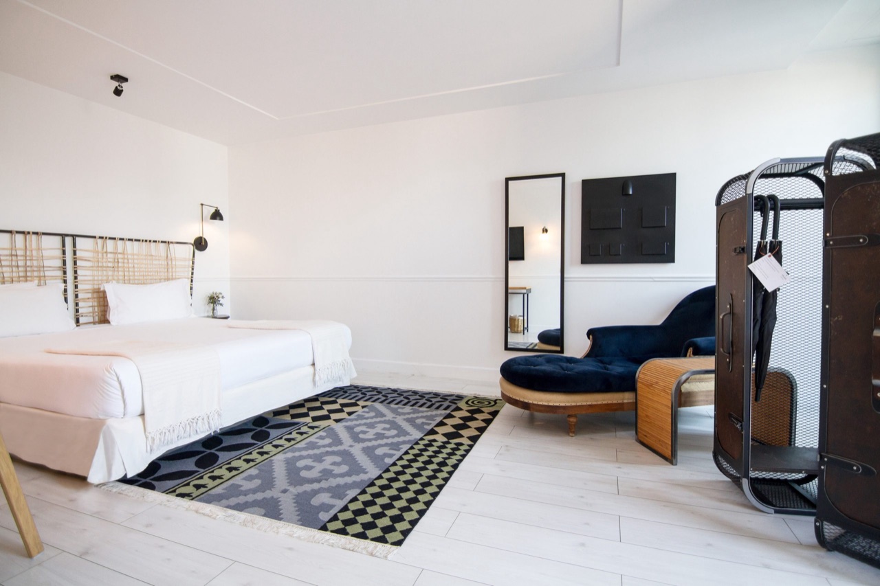 A top-floor Ático con Terraza room with a rattan headboard, a blue velvet chaise longue, and a full-length mirror.