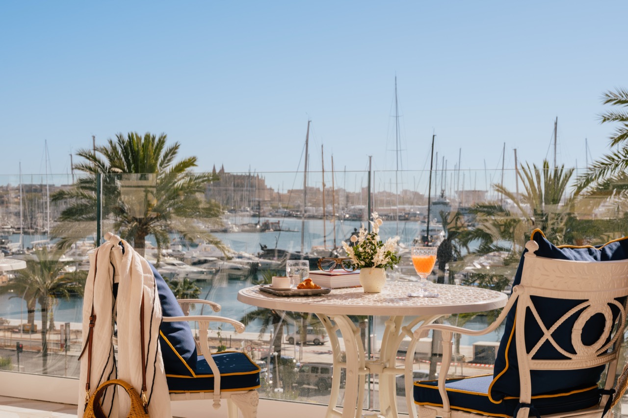 Balcony table set with breakfast overlooking palm trees and the marina