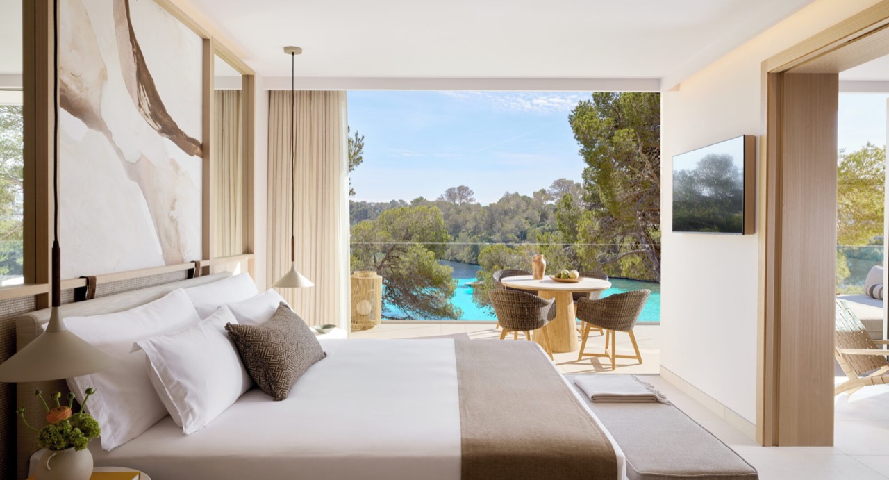 Bedroom with a bed facing an open terrace, pool and pine trees
