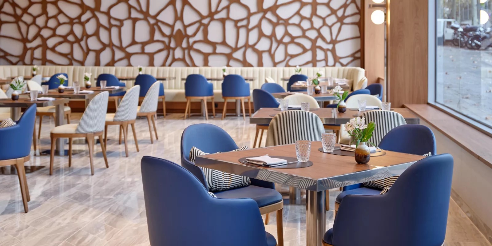 Restaurant dining room with blue chairs and a carved wood wall panel