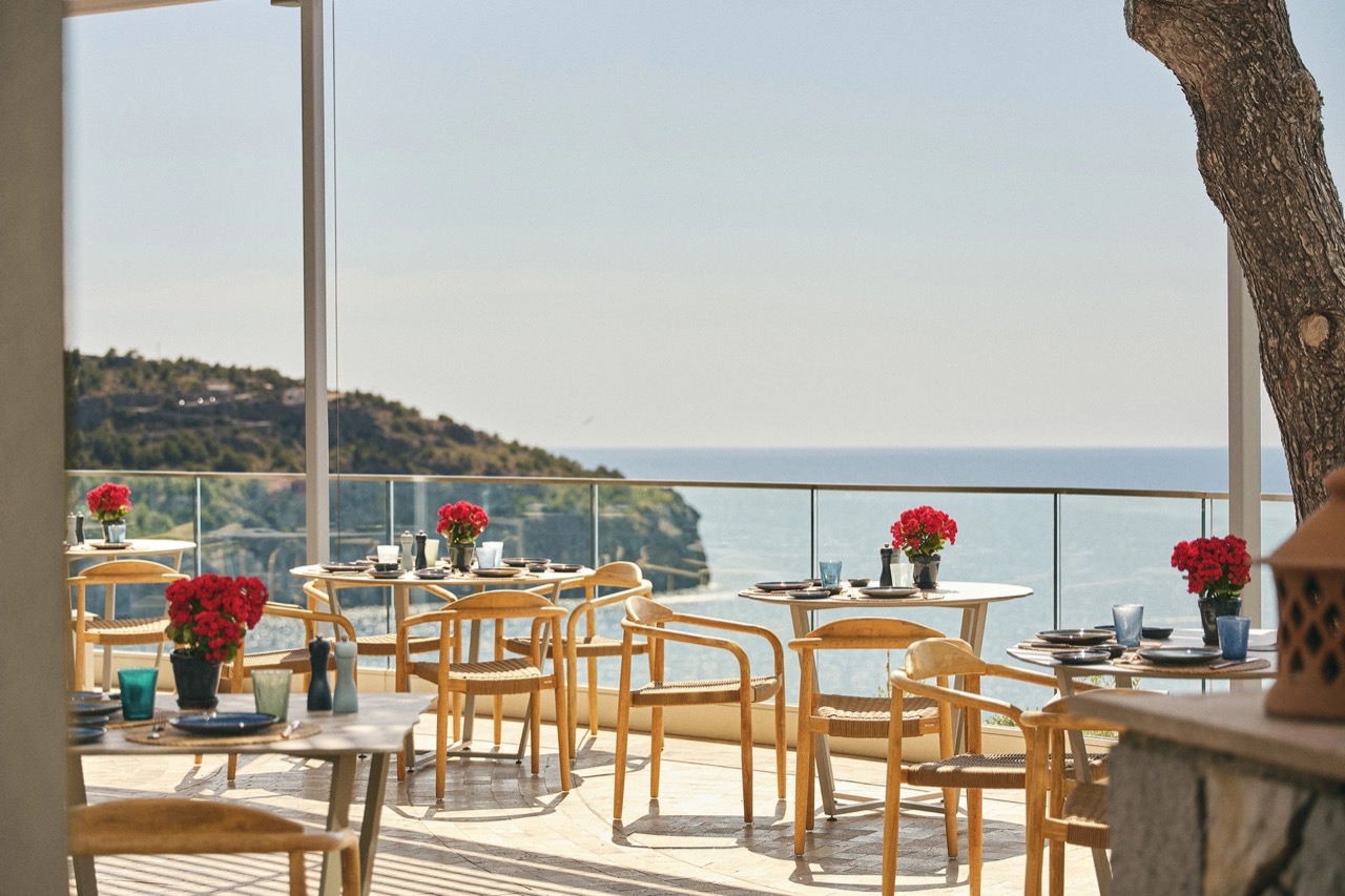 Restaurant terrace tables set with flowers overlooking the sea