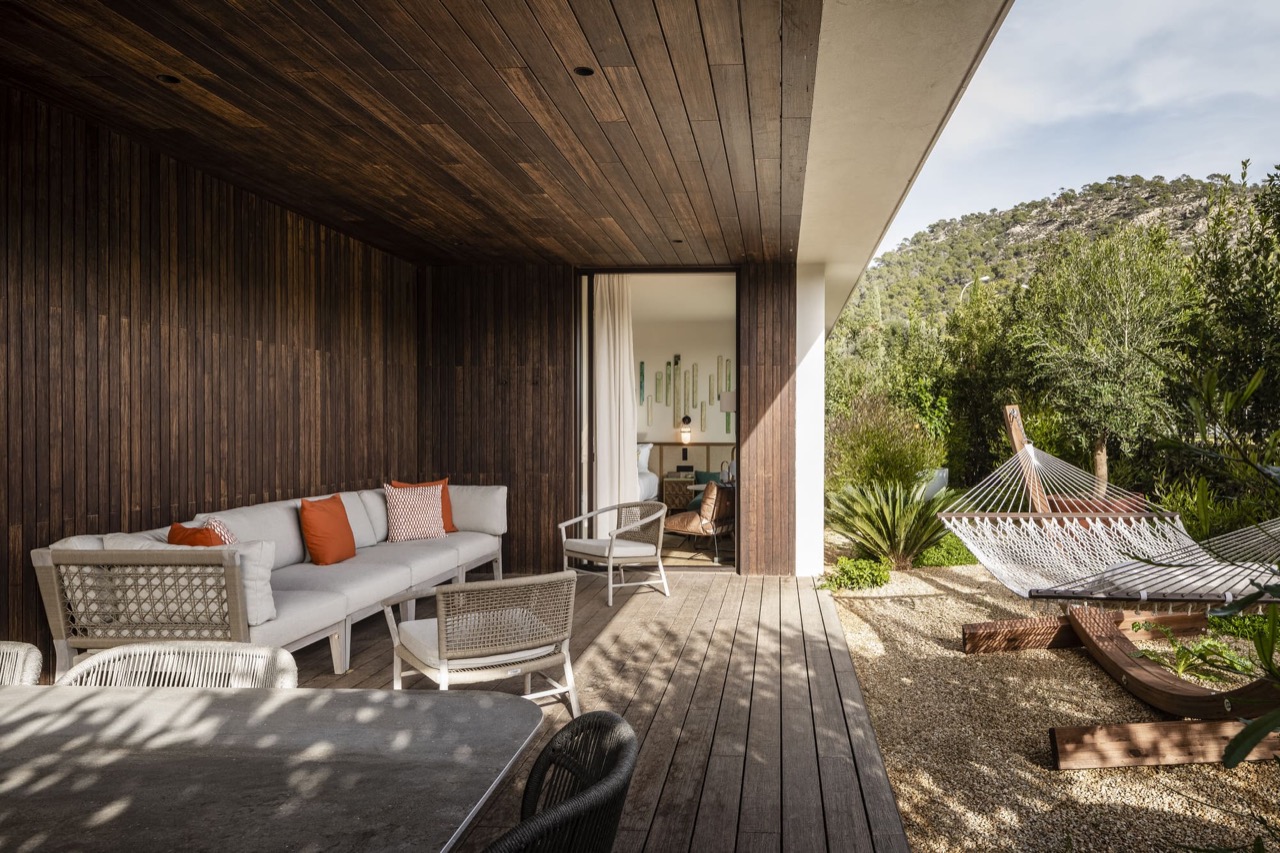 Private garden terrace at Kimpton Aysla Mallorca with lounge seating, a hammock and mountain views