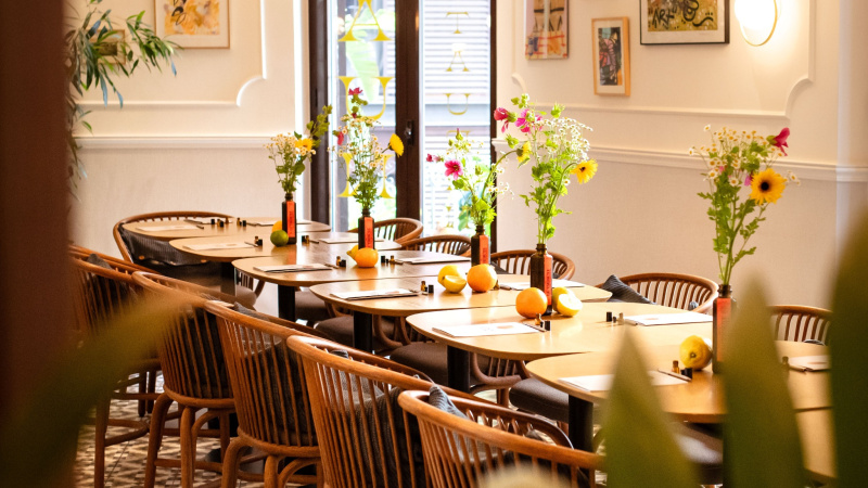 Restaurant dining room with set tables, fresh flowers and framed art