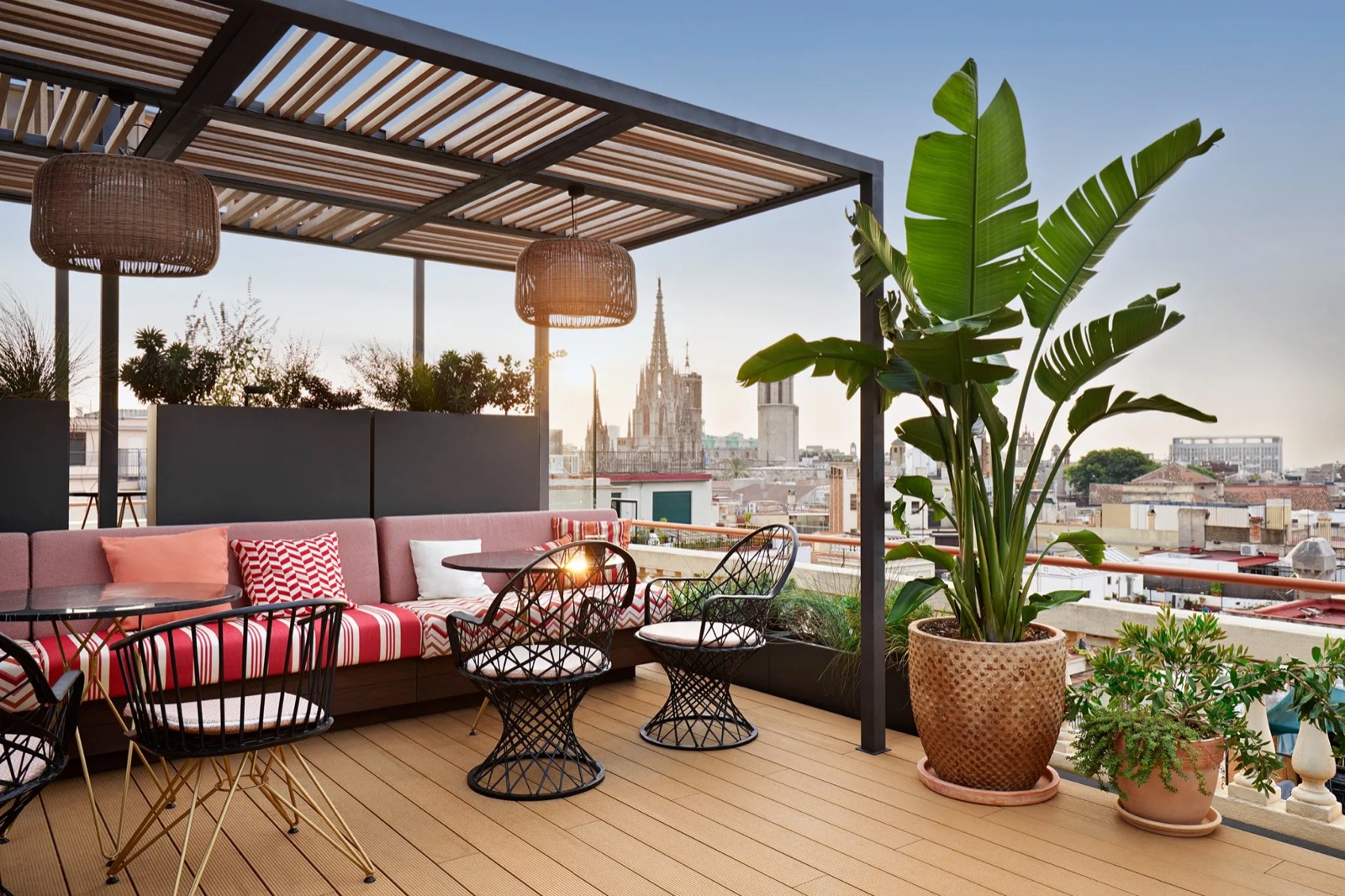 Rooftop terrace with wicker pendant lamps and Barcelona Cathedral behind