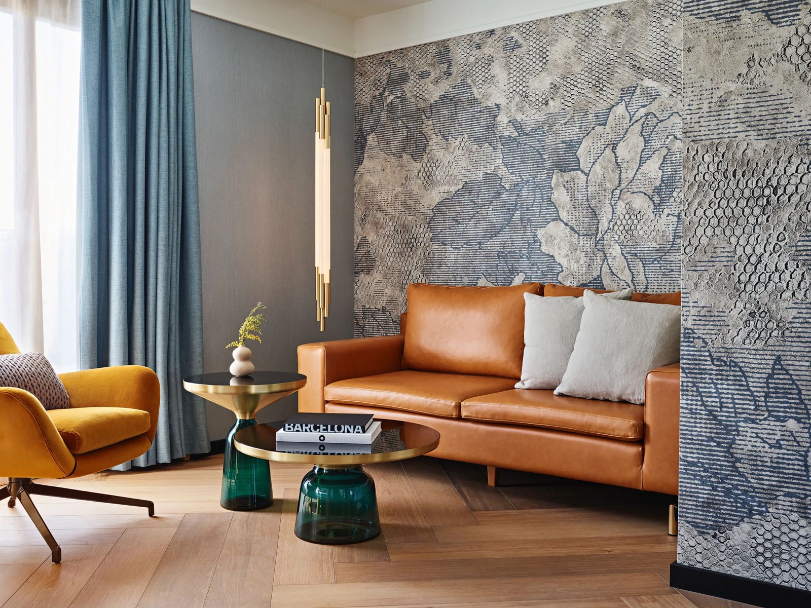 Suite de Vivi living area with a tan leather sofa and a mustard armchair