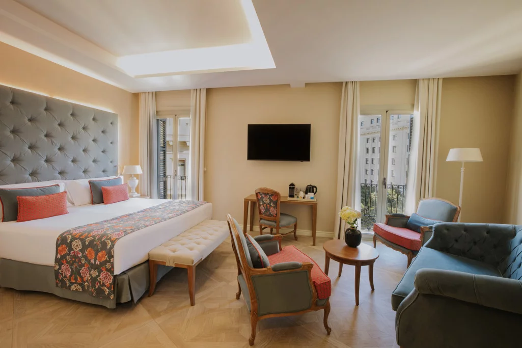 Executive room with a king bed, a grey tufted headboard and a desk