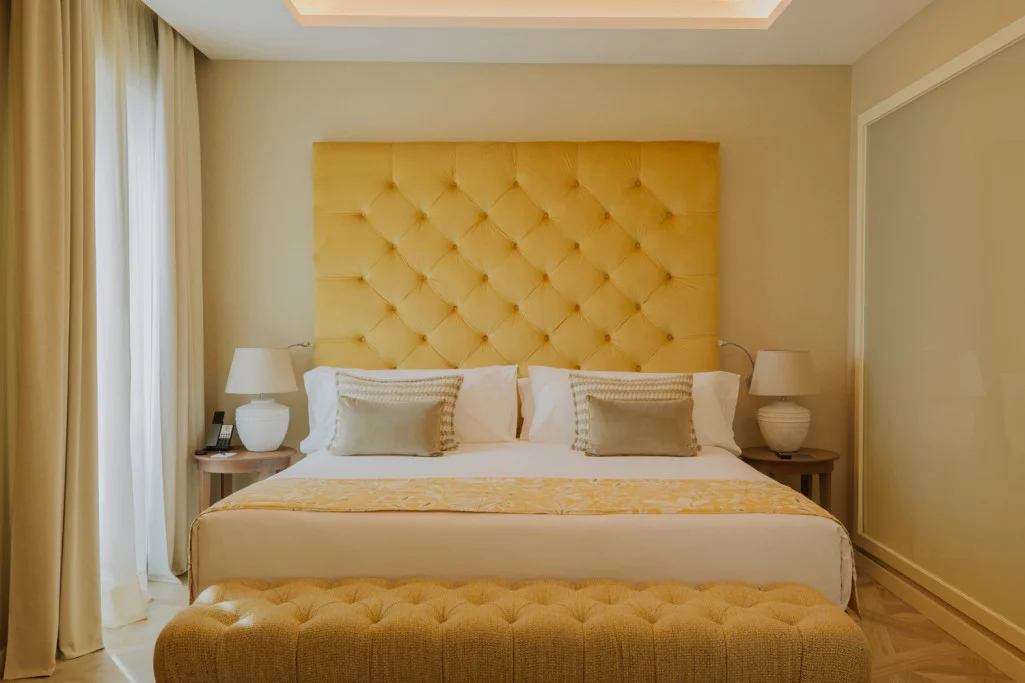 Grand Master Suite bedroom with a mustard-yellow tufted headboard