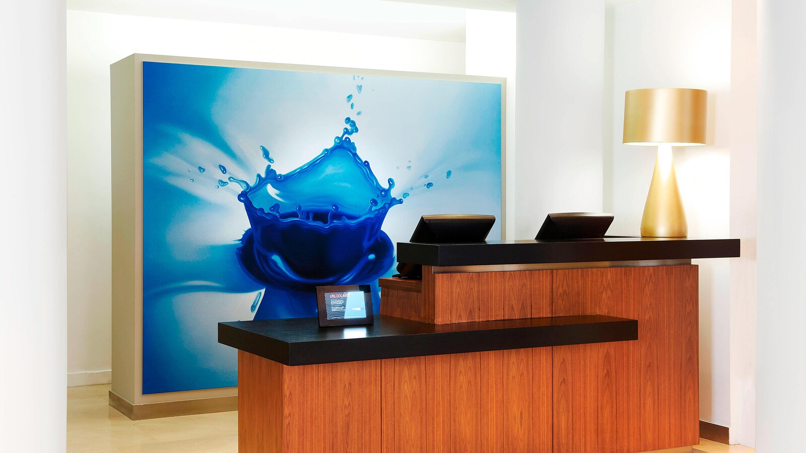 Reception area with a wood-paneled counter and an art installation