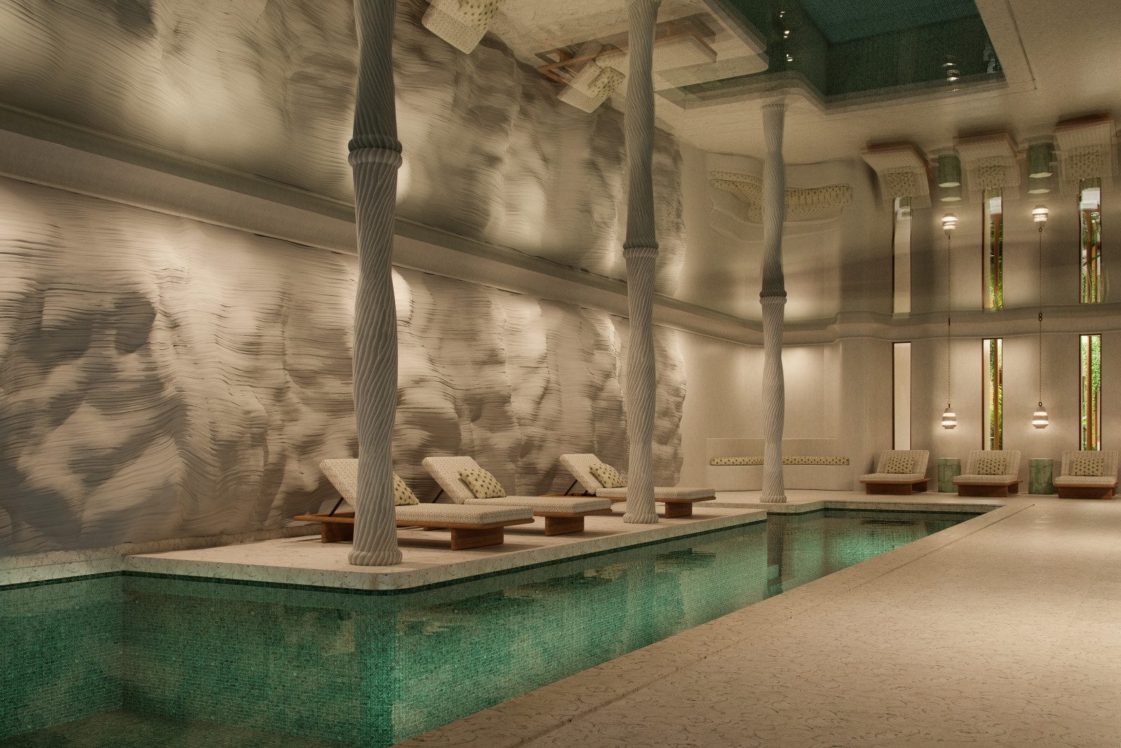 Indoor spa pool at Mandarin Oriental Punta Negra with textured stone walls, carved columns, and cushioned loungers along a green-tiled pool edge