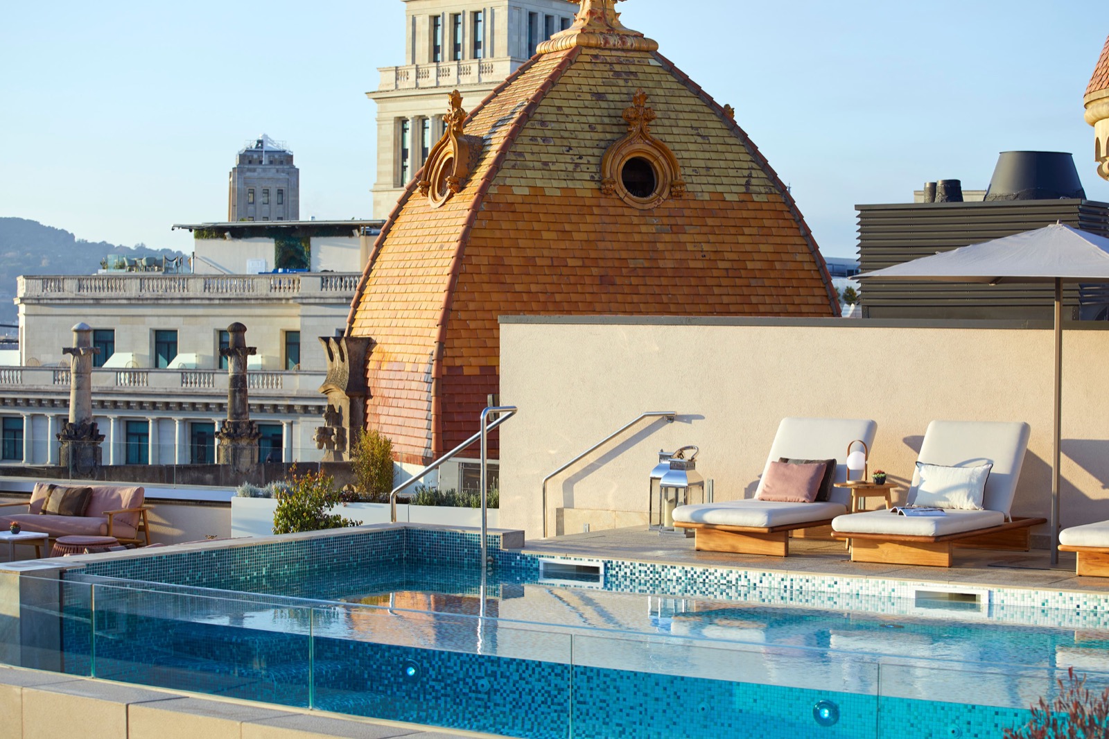 Rooftop plunge pool and loungers with a historic domed tower behind