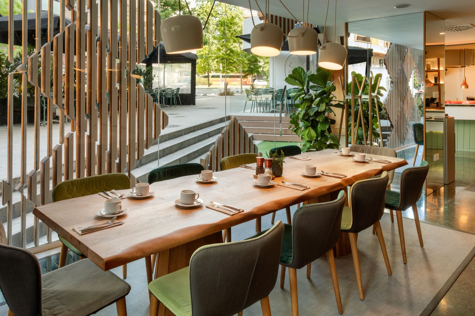 Restaurant table set for breakfast beside floor-to-ceiling street windows