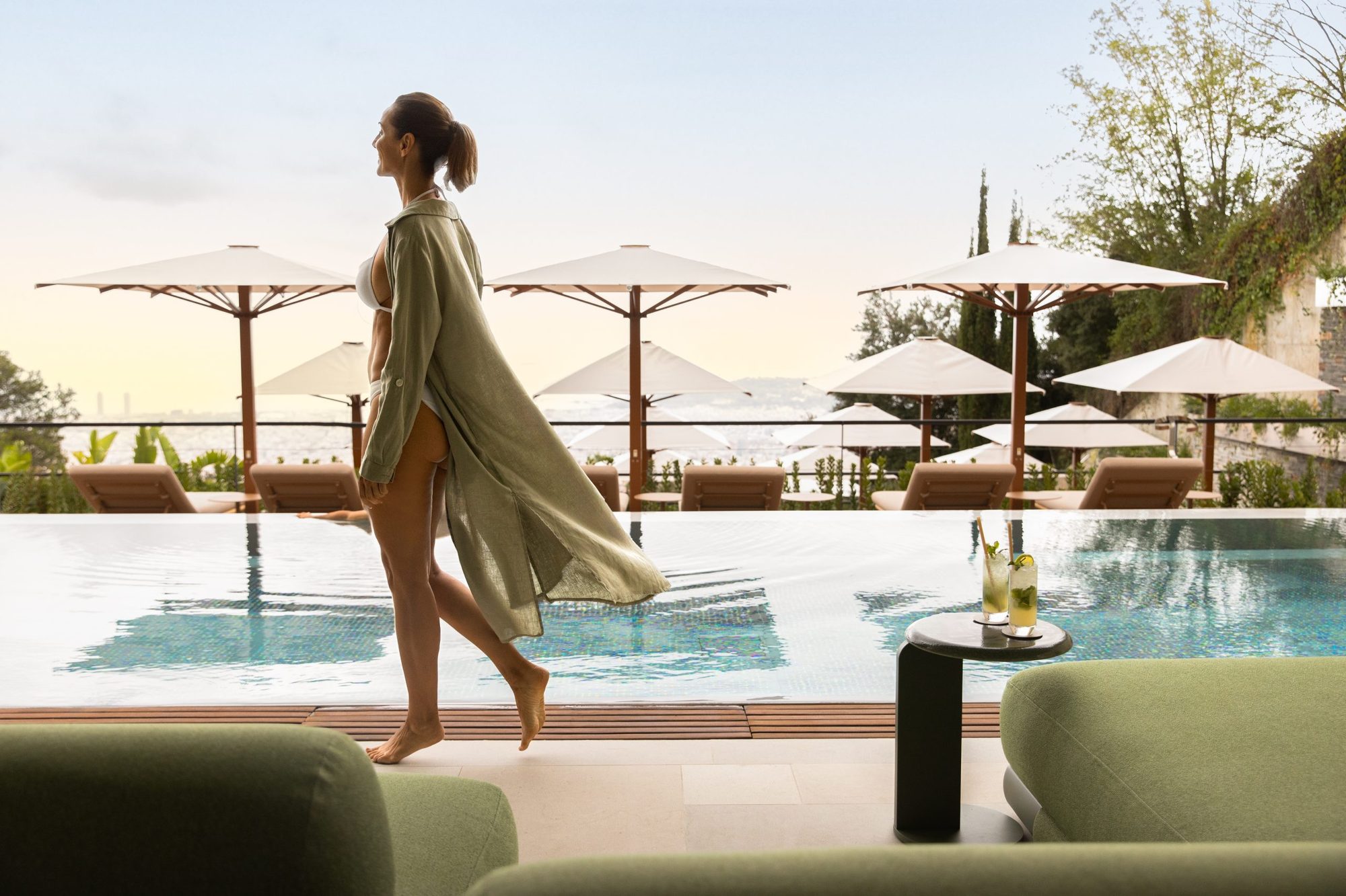 Infinity pool at the Pool Club, METT Barcelona, lined with cream sun umbrellas and loungers overlooking the Barcelona skyline