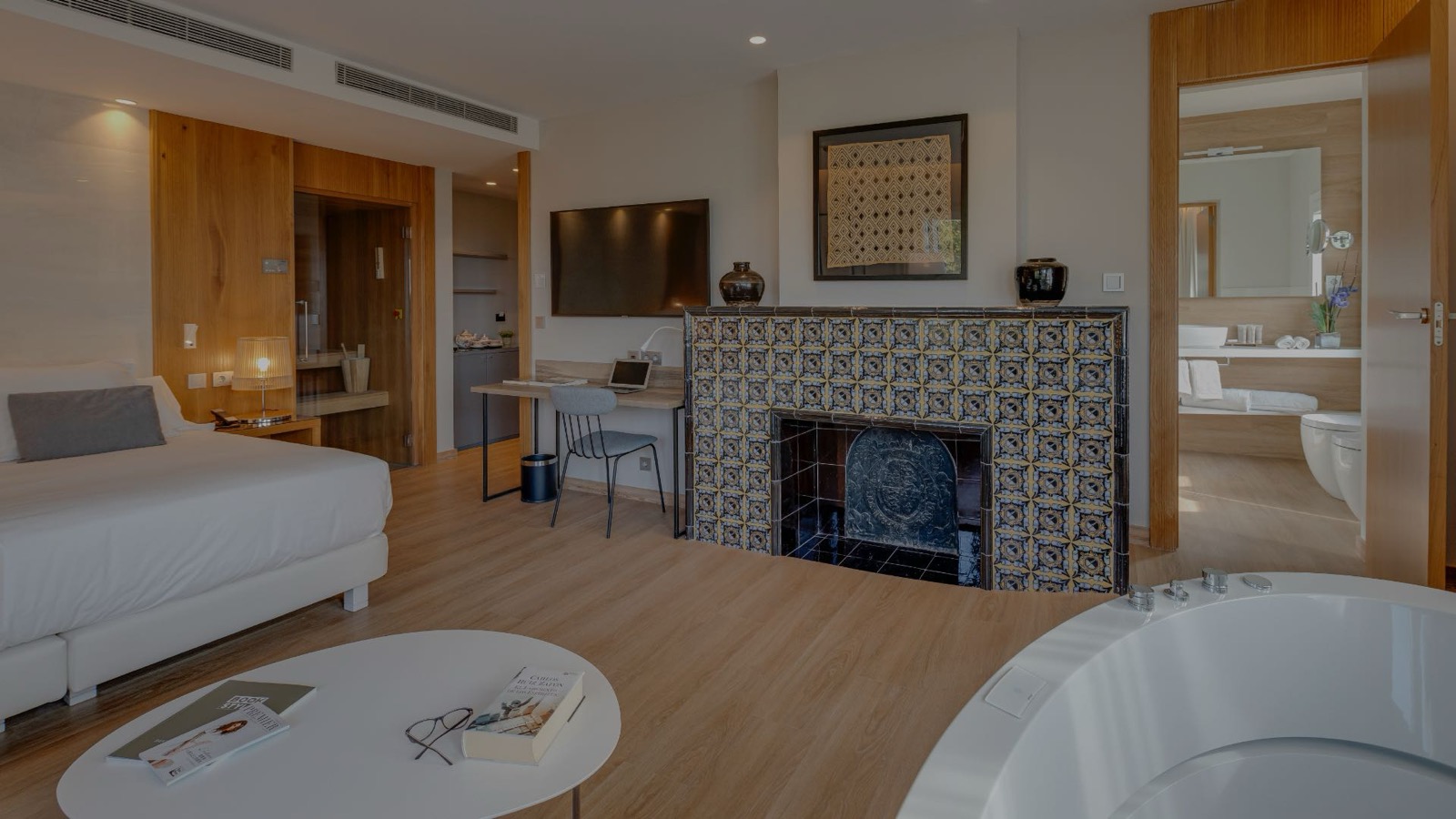 Lobby lounge with a grand wooden staircase, a fireplace and an art wall