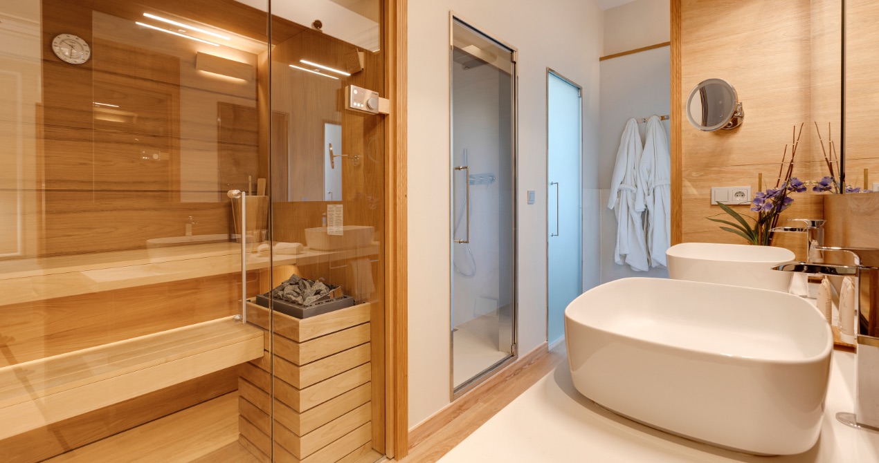 In-room sauna and bathroom with a glass-enclosed shower and robes