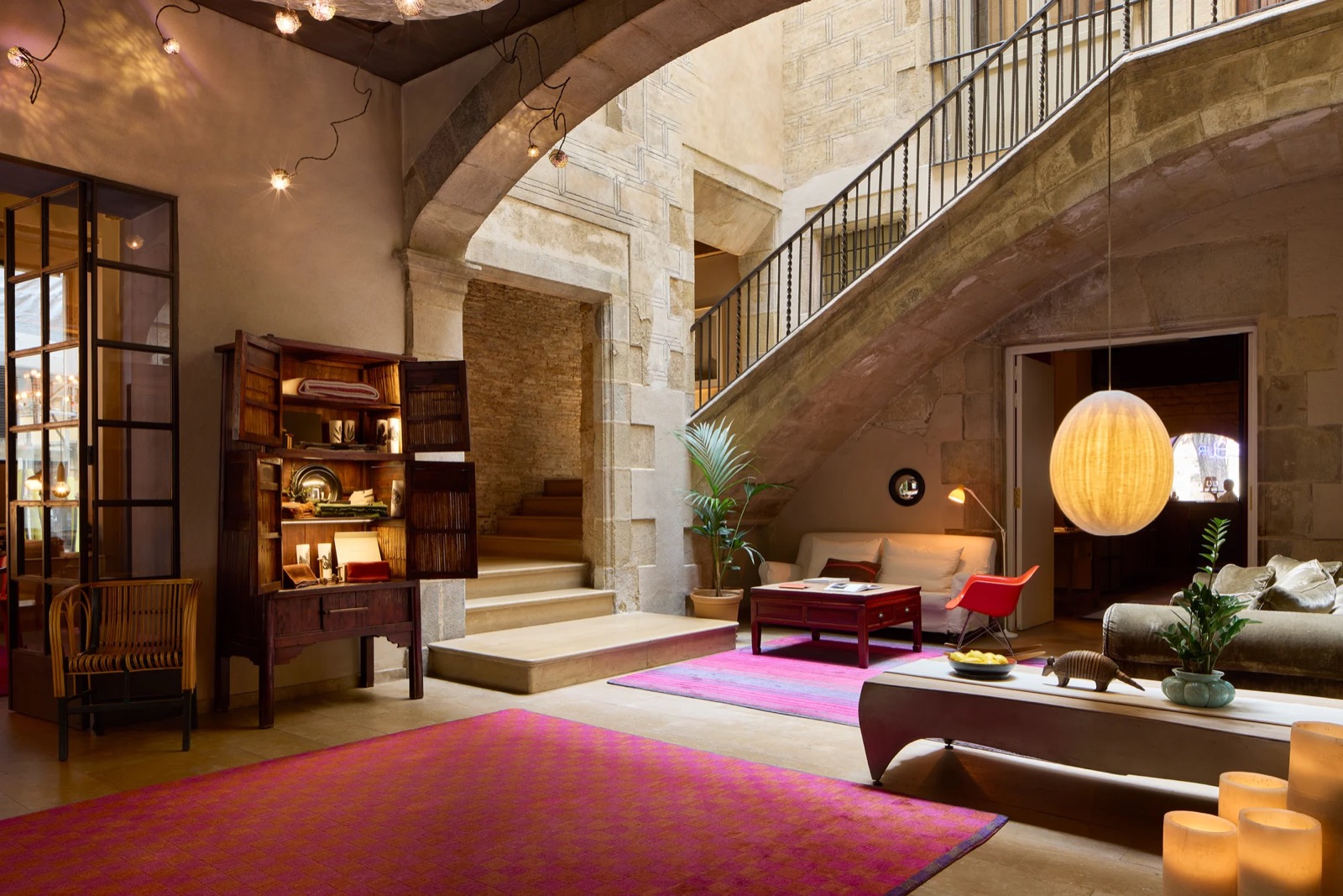 Hotel Neri's stone-vaulted lobby with a staircase and courtyard light