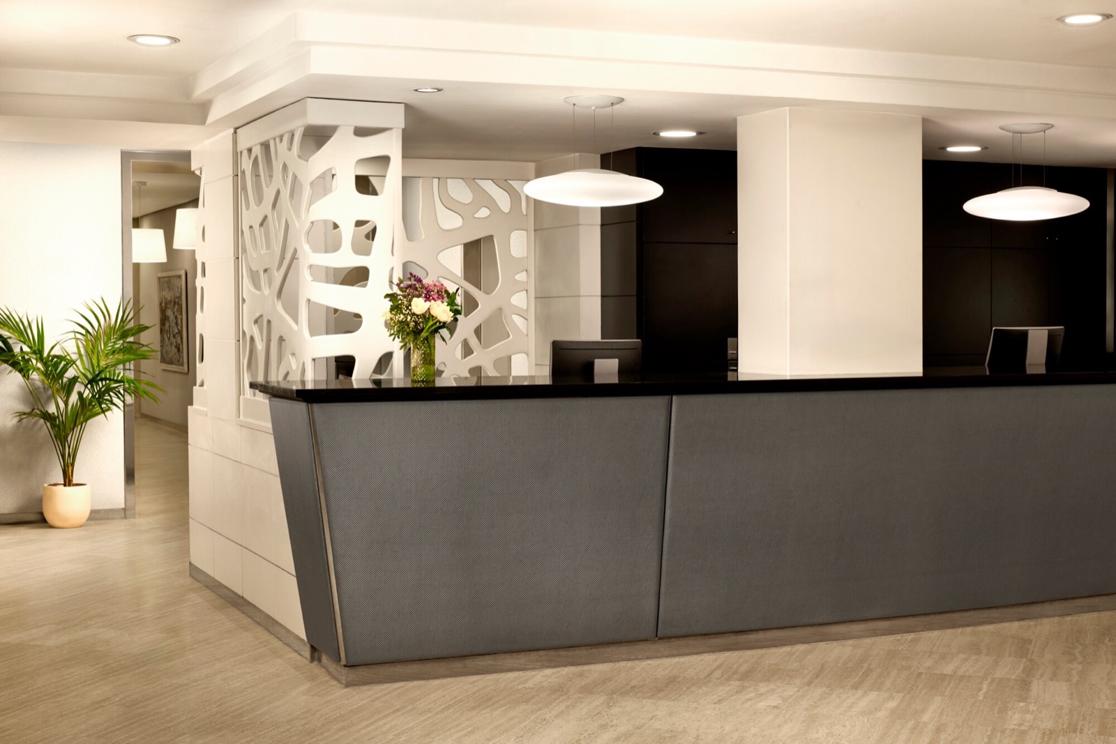Lobby reception with a sculptural white partition and pendant lights