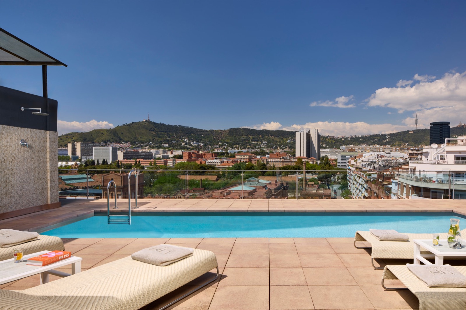 Rooftop pool with sun loungers overlooking Barcelona and Tibidabo hill